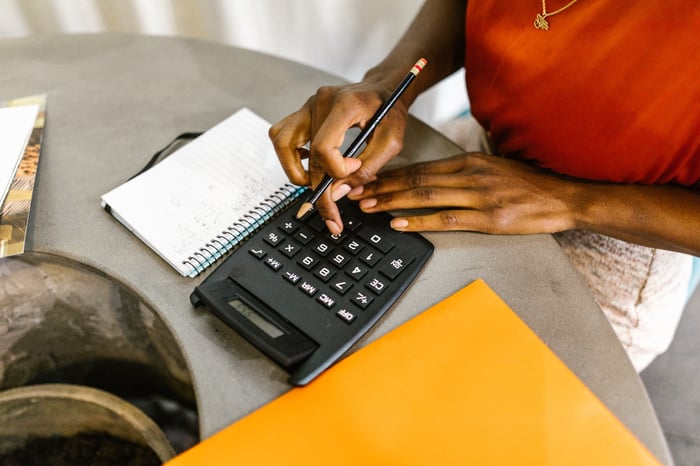 Woman Uses Calculator [Photo by RODNAE Productions on Pexels]